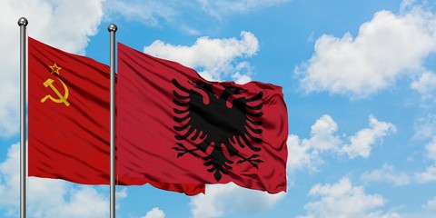 Soviet Union and Albania flag waving in the wind against white cloudy blue sky together. Diplomacy concept, international relations.