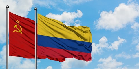 Soviet Union and Colombia flag waving in the wind against white cloudy blue sky together. Diplomacy concept, international relations.
