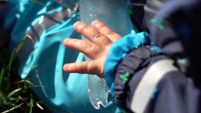 a kid holds a piece of ice in winter