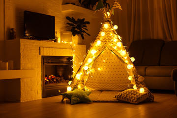 interior of a children's playroom with a tent, lamps and toys in dark © Angelov