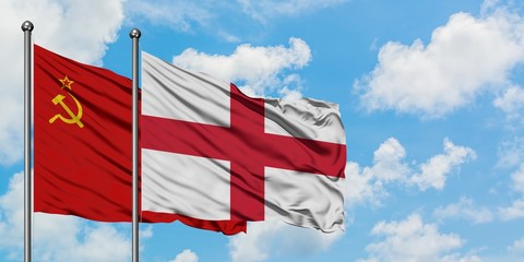 Soviet Union and England flag waving in the wind against white cloudy blue sky together. Diplomacy concept, international relations.