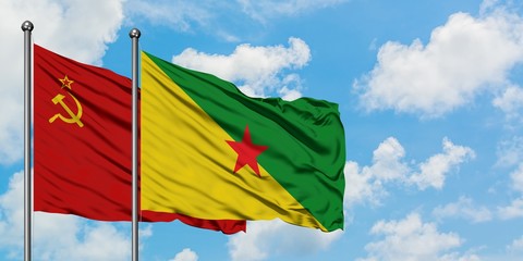 Soviet Union and French Guiana flag waving in the wind against white cloudy blue sky together. Diplomacy concept, international relations.