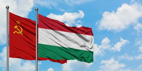 Soviet Union and Hungary flag waving in the wind against white cloudy blue sky together. Diplomacy concept, international relations.