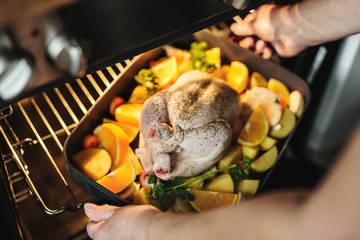 Woman cooking raw chicken with vegetables