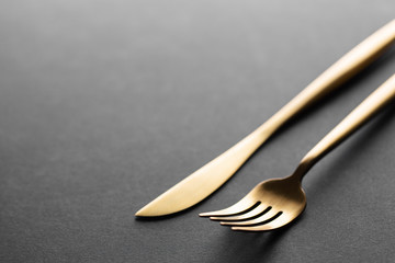 Gold cutlery set on black background