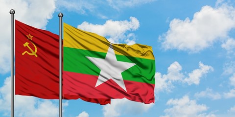 Soviet Union and Myanmar flag waving in the wind against white cloudy blue sky together. Diplomacy...