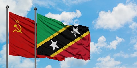 Soviet Union and Saint Kitts And Nevis flag waving in the wind against white cloudy blue sky together. Diplomacy concept, international relations.