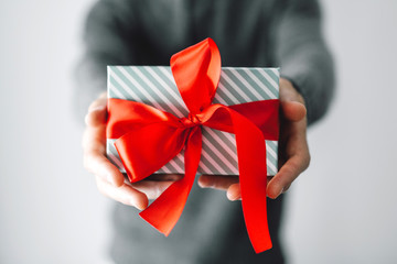 Man holding gift with red ribbon