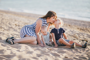 Fototapeta na wymiar Happy mother and her children posing at beach.
