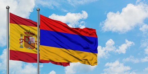 Spain and Armenia flag waving in the wind against white cloudy blue sky together. Diplomacy concept, international relations.