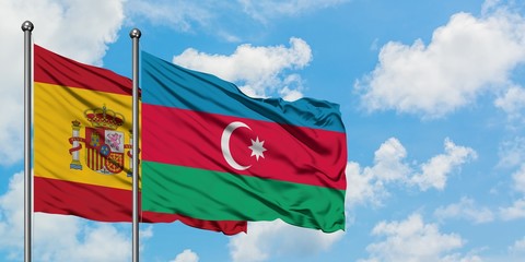 Spain and Azerbaijan flag waving in the wind against white cloudy blue sky together. Diplomacy concept, international relations.