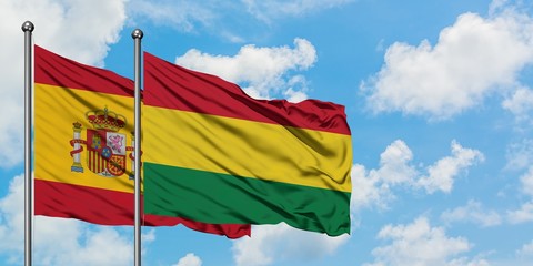 Spain and Bolivia flag waving in the wind against white cloudy blue sky together. Diplomacy concept, international relations.