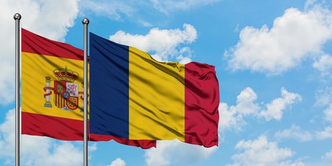 Spain and Chad flag waving in the wind against white cloudy blue sky together. Diplomacy concept, international relations.