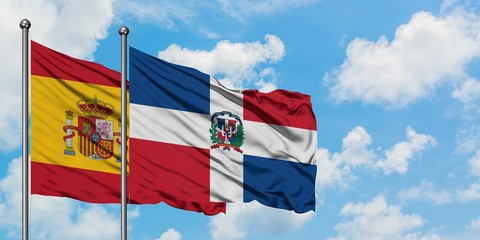 Spain and Dominican Republic flag waving in the wind against white cloudy blue sky together. Diplomacy concept, international relations.