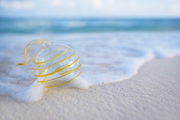clear christmas glass ball on beach