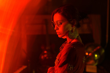 Young attractive girl in national indian clothes and jewelry. Cinematic style, creative color