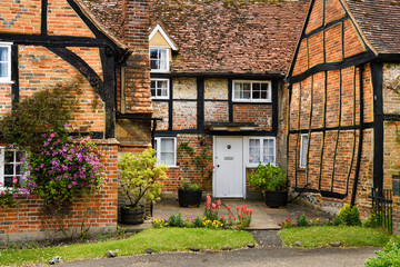 Red brick and roof tile tudor house with crooked wood beams of Church Cottage rectory at St Mary the Virgin in Turville village England
