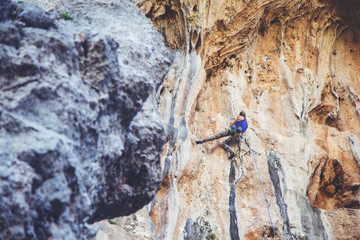 Woman climbs a rock.