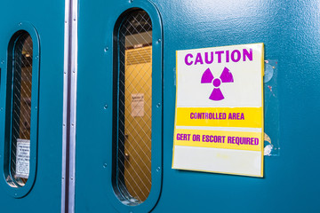 Ionizing radiation warning symbol displayed at the entrance to a laboratory; Message posted: "Controlled Area; Gert or Escort Required"; Gert stands for General Employee Radiological Training