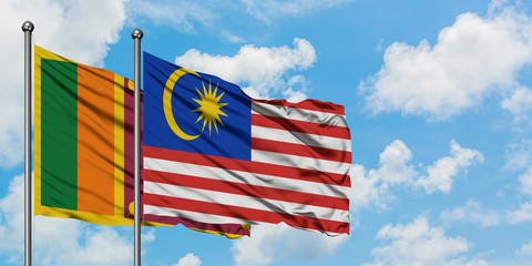 Sri Lanka and Malaysia flag waving in the wind against white cloudy blue sky together. Diplomacy concept, international relations.