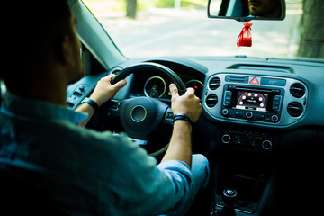 Driver man sitting in his car or van and is driving looking back