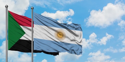 Sudan and Argentina flag waving in the wind against white cloudy blue sky together. Diplomacy concept, international relations.
