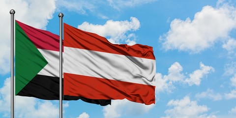 Sudan and Austria flag waving in the wind against white cloudy blue sky together. Diplomacy concept, international relations.