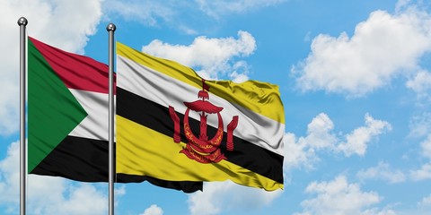 Sudan and Brunei flag waving in the wind against white cloudy blue sky together. Diplomacy concept, international relations.
