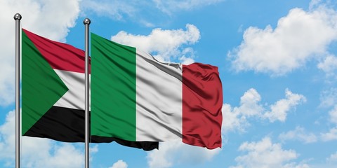 Sudan and Italy flag waving in the wind against white cloudy blue sky together. Diplomacy concept, international relations.