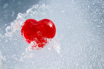 Red heart in ice. Close-up. Background. Texture.