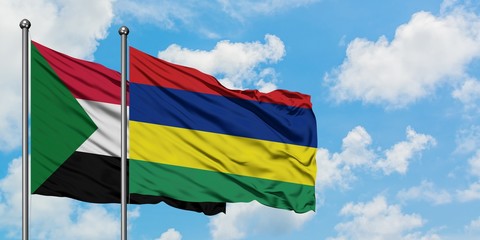 Sudan and Mauritius flag waving in the wind against white cloudy blue sky together. Diplomacy concept, international relations.