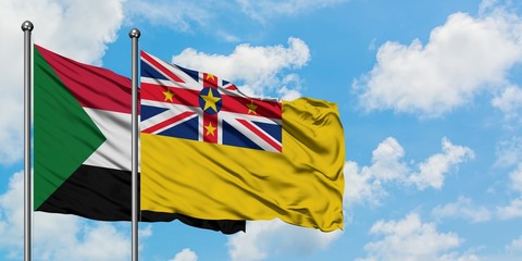 Sudan and Niue flag waving in the wind against white cloudy blue sky together. Diplomacy concept, international relations.