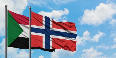 Sudan and Norway flag waving in the wind against white cloudy blue sky together. Diplomacy concept, international relations.