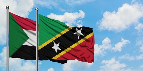 Sudan and Saint Kitts And Nevis flag waving in the wind against white cloudy blue sky together. Diplomacy concept, international relations.
