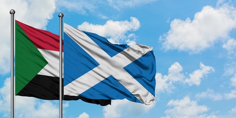 Sudan and Scotland flag waving in the wind against white cloudy blue sky together. Diplomacy concept, international relations.