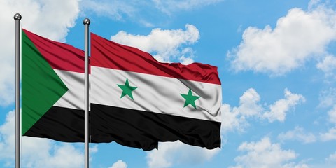 Sudan and Syria flag waving in the wind against white cloudy blue sky together. Diplomacy concept,...