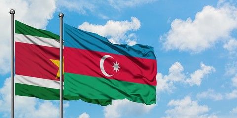 Suriname and Azerbaijan flag waving in the wind against white cloudy blue sky together. Diplomacy concept, international relations.