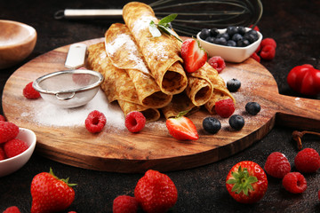 Delicious Tasty Homemade crepes or pancakes with raspberries and mint on rustic background