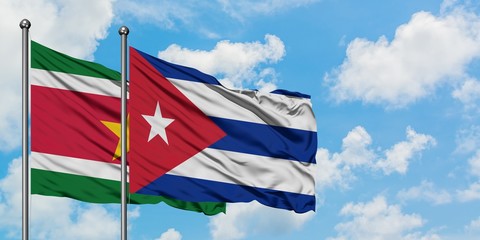 Suriname and Cuba flag waving in the wind against white cloudy blue sky together. Diplomacy concept, international relations.