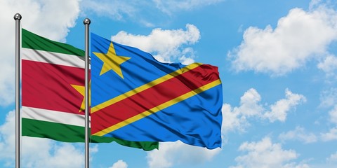 Suriname and Congo flag waving in the wind against white cloudy blue sky together. Diplomacy concept, international relations.