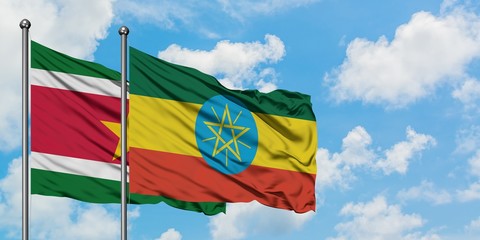 Suriname and Ethiopia flag waving in the wind against white cloudy blue sky together. Diplomacy concept, international relations.