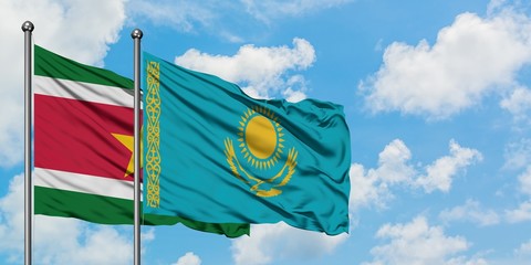 Suriname and Kazakhstan flag waving in the wind against white cloudy blue sky together. Diplomacy concept, international relations.