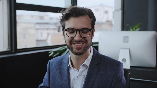 Portrait of handsome caucasian businessman working by computer in corporate office enjoying modern profession career in the company. Close-up.