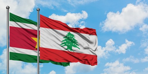 Suriname and Lebanon flag waving in the wind against white cloudy blue sky together. Diplomacy concept, international relations.