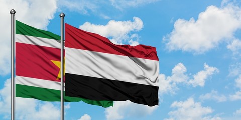Suriname and Yemen flag waving in the wind against white cloudy blue sky together. Diplomacy concept, international relations.
