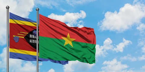 Swaziland and Burkina Faso flag waving in the wind against white cloudy blue sky together. Diplomacy concept, international relations.