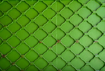 Close-up of an old metal grate bright green painted background, Italy