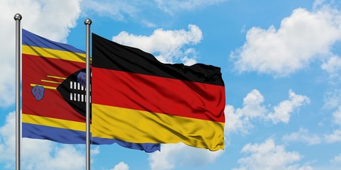 Swaziland and Germany flag waving in the wind against white cloudy blue sky together. Diplomacy concept, international relations.