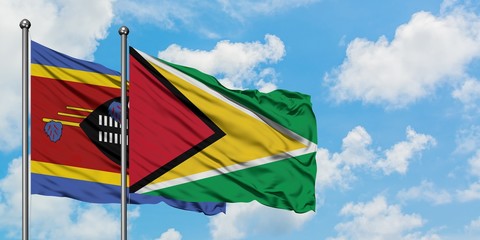 Swaziland and Guyana flag waving in the wind against white cloudy blue sky together. Diplomacy concept, international relations.