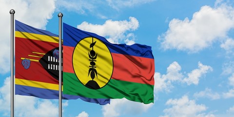 Swaziland and New Caledonia flag waving in the wind against white cloudy blue sky together. Diplomacy concept, international relations.